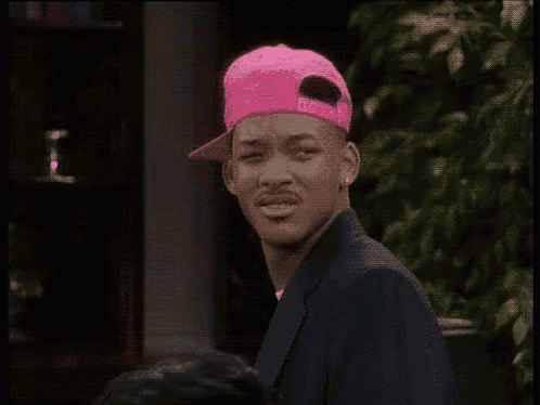 will smith is wearing a pink hat and a blue suit .