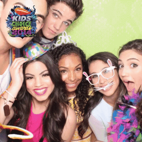 a group of people posing for a photo with a kids choice awards 2014 logo