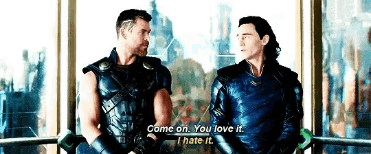 two men are standing next to each other and talking .