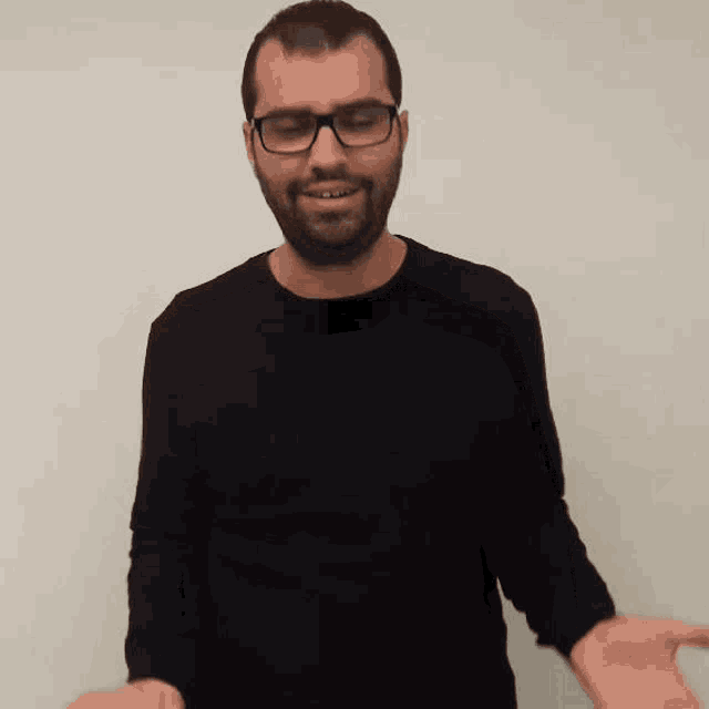 a man with glasses and a beard wearing a black sweater