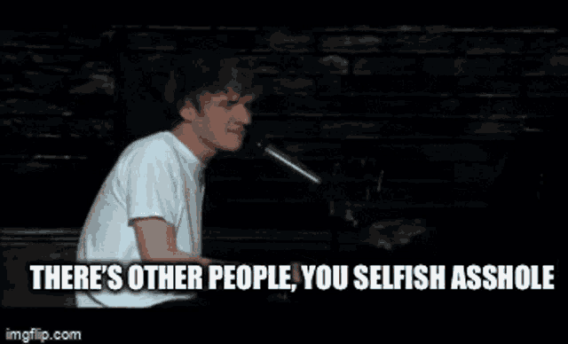 a man singing into a microphone with the words " there 's other people you selfish asshole "