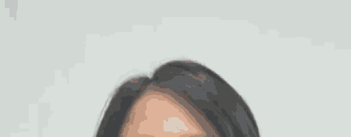 a close up of a woman 's face with long black hair against a white background .