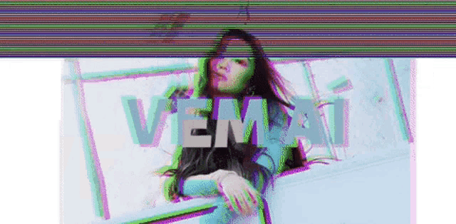 a woman in a blue dress is sitting in front of a window with the word vema written on it .