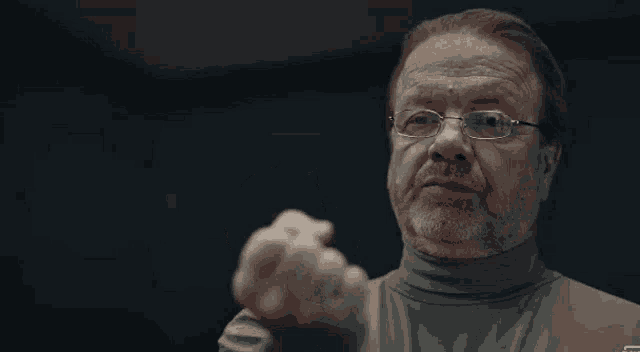 a man in glasses is giving a thumbs up sign