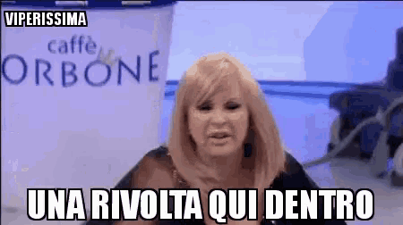 a woman with blonde hair says una rivolta qui dentro