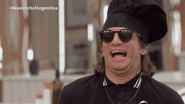 a man wearing sunglasses and a chef 's hat is laughing in front of a masterchef argentina logo