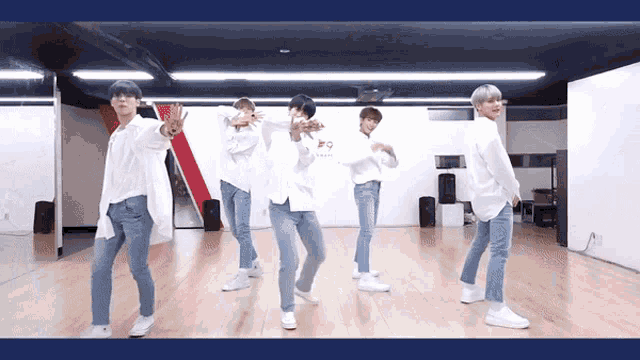 a group of young men are dancing in a dance studio with a sign on the wall that says t9