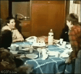 a group of people are sitting around a table with plates and cups