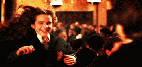 a man in a suit and tie is dancing in a crowd .