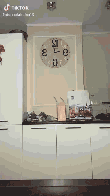 a kitchen with a clock hanging on the wall and a tiktok watermark