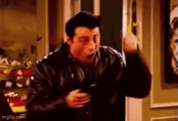 a man in a black leather jacket is standing in front of a door and making a surprised face .