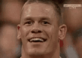 a close up of a man 's face with his mouth open and a crowd in the background .
