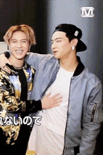 two men are standing next to each other and one of them is hugging the other ..