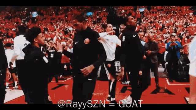 a group of basketball players are dancing in front of a crowd with the caption " rayyszn = goat " at the bottom