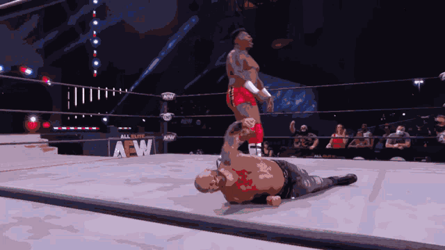 a wrestler in a ring with a sign that says aew in the background
