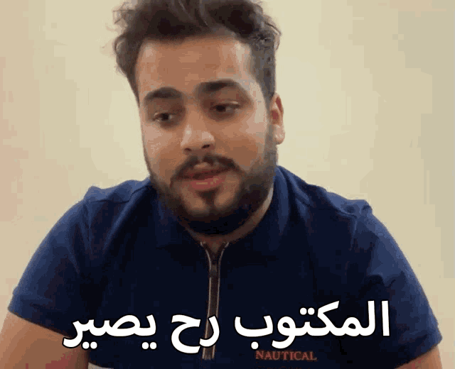 a man with a beard wears a blue shirt that says nautical