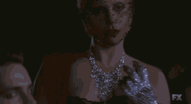 a woman wearing a veil and a necklace with fx written on the bottom of the screen