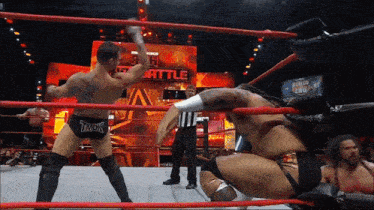 two wrestlers in a ring with a referee and a sign that says worlds heavyweight championship