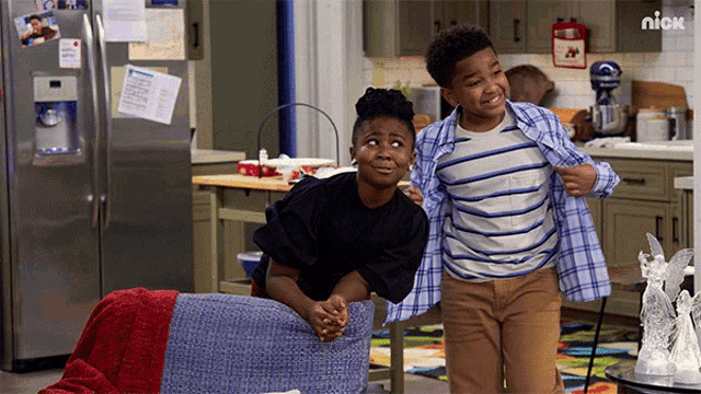 a boy and a girl are standing next to each other in a kitchen with a nick logo in the background