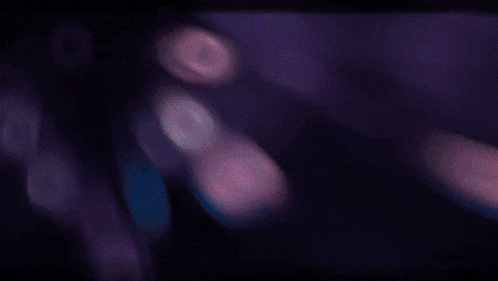 a purple light is shining on a black background