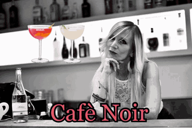 a woman sits at a bar with a sign that says " cafe noir "