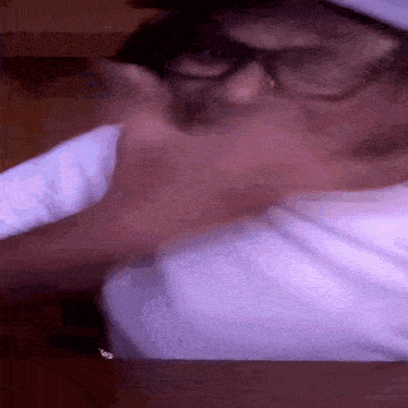 a close up of a person wearing glasses and a white shirt