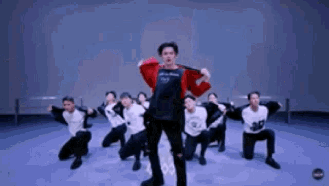 a group of young men are dancing on a stage in a dance studio .