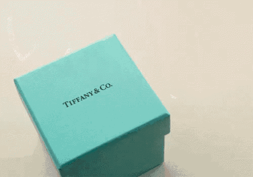 a blue box from tiffany & co. with pink hearts coming out of it