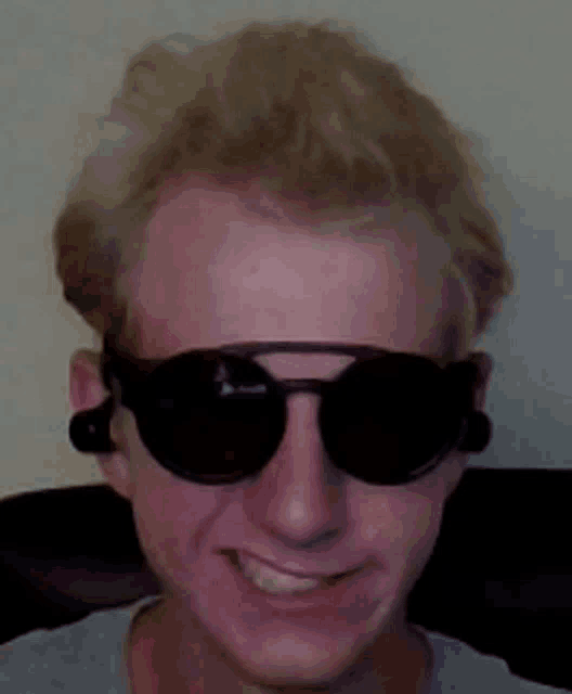 a man wearing sunglasses and ear buds is smiling
