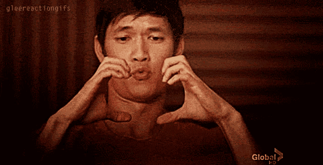 a man making a face with his hands and the words glee reaction gifs above him