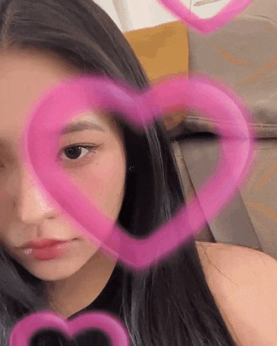a close up of a woman 's face with pink hearts around it