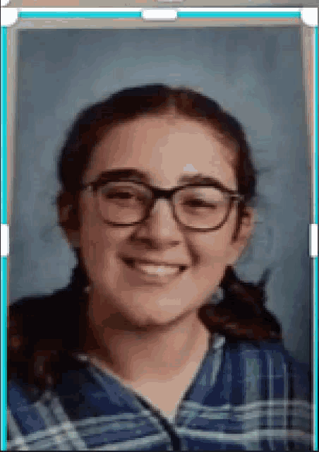 a young girl wearing glasses and a plaid shirt is smiling in a picture frame .