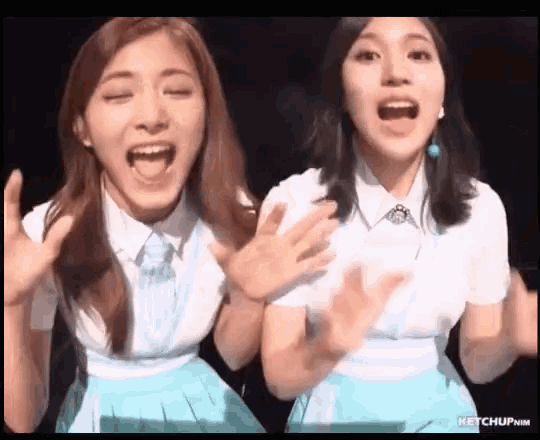 two women are standing next to each other with their mouths open