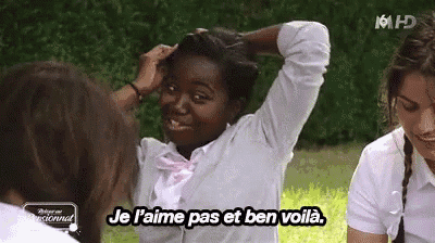 a woman in a white shirt with a pink bow tie says je l' aime pas et ben voila .