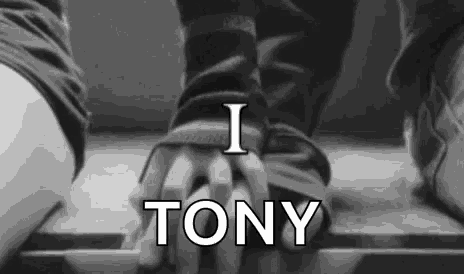 a black and white photo of a person holding another person 's hand with the words `` i tony '' written above them .