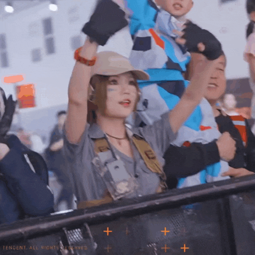 a woman holding a child behind a fence with the letters tencent on it