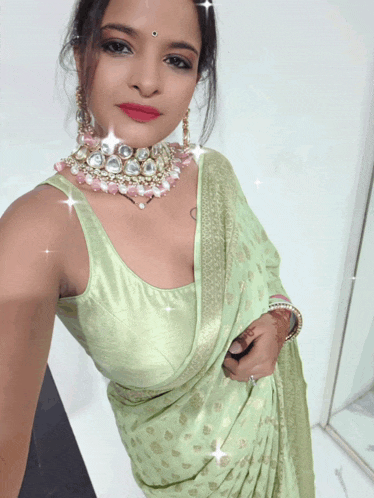 a woman is wearing a green blouse and a choker with pearls