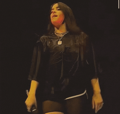 a woman is wearing a black shirt with a batman logo on the front