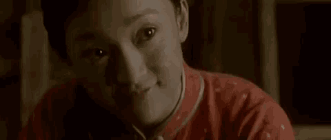 a close up of a woman 's face in a red dress .