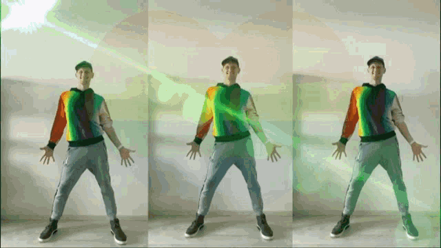 a man in a rainbow sweater is dancing with a green light coming out of his eyes