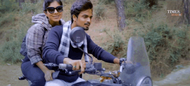 a man and a woman are riding a motorcycle with times india written on the bottom of the screen