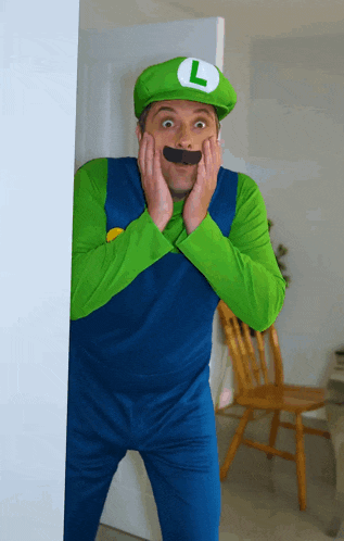 a man in a luigi costume with a l on his hat