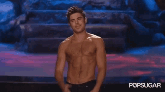 a shirtless man is saluting on a stage .