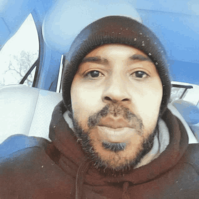 a man with a beard is wearing a beanie and a hoodie