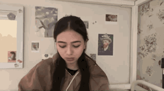 a woman is standing in front of a wall with pictures on it