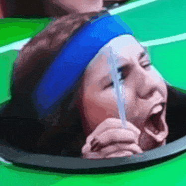 a woman wearing a blue headband is holding a straw