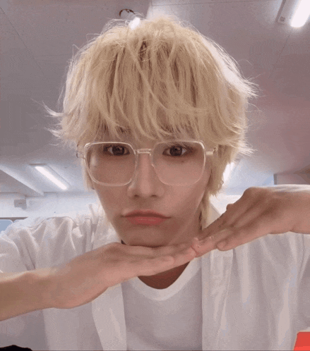 a person wearing glasses and a white shirt making a funny face