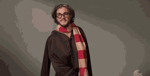 a shirtless man with glasses and a scarf around his neck is flying through the air .