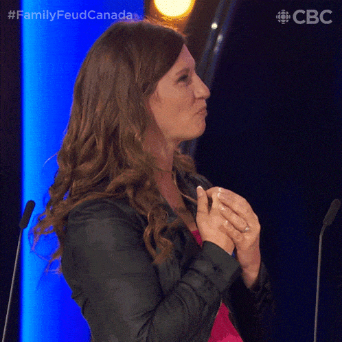 a woman is clapping her hands in front of a microphone with the hashtag familyfeud canada