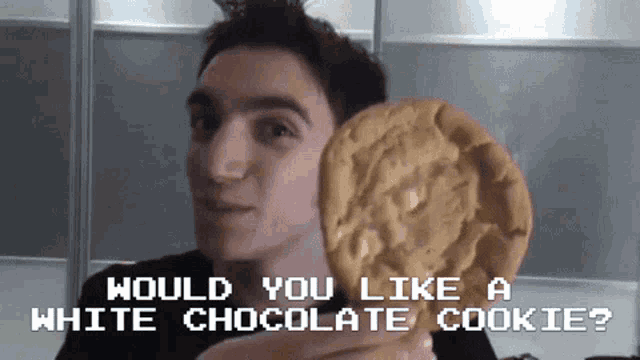 a man holding a white chocolate cookie with the words would you like a white chocolate cookie